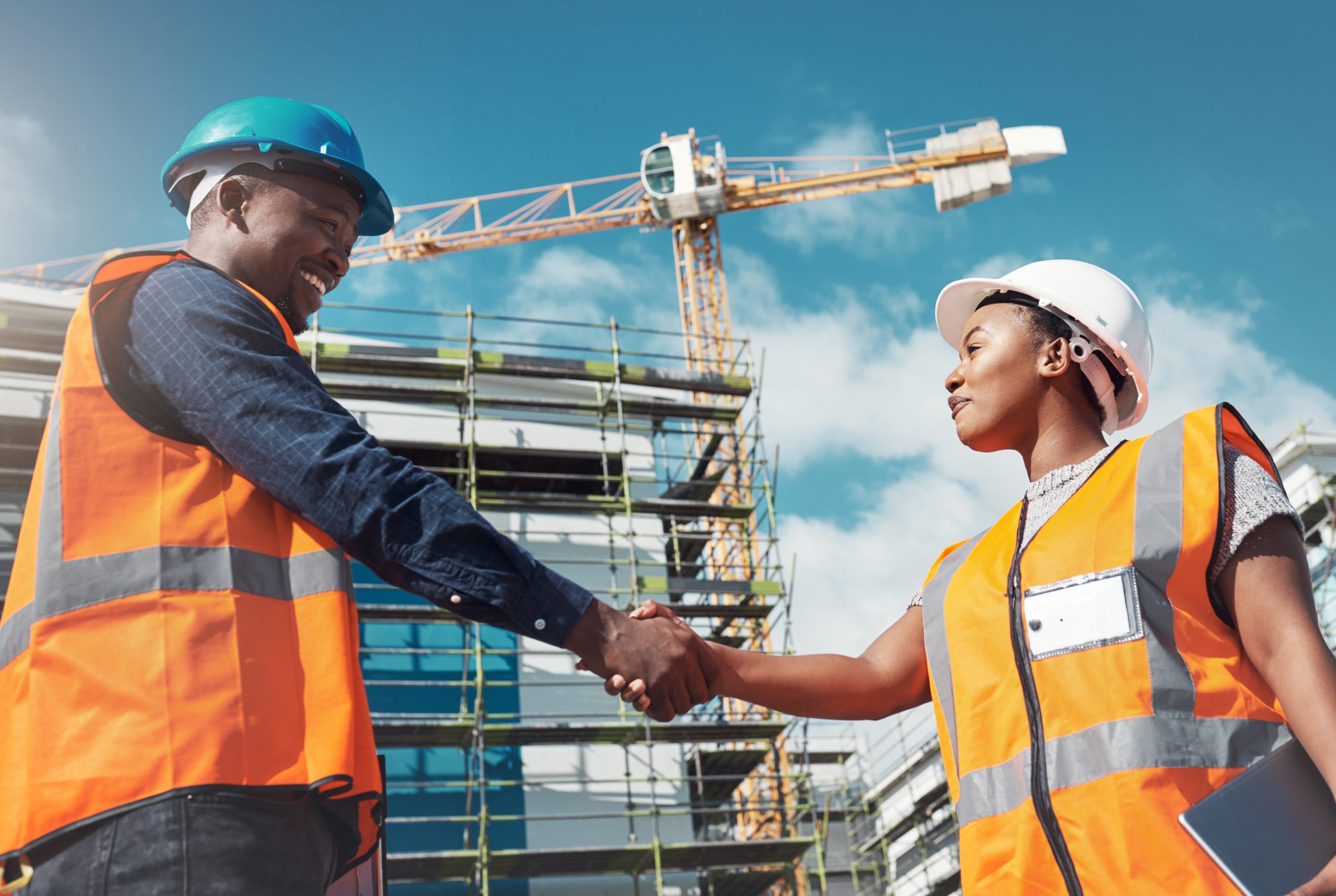 Shot of two builders shaking hands at a construction site. Shot of two builders shaking hands at a construction site.
